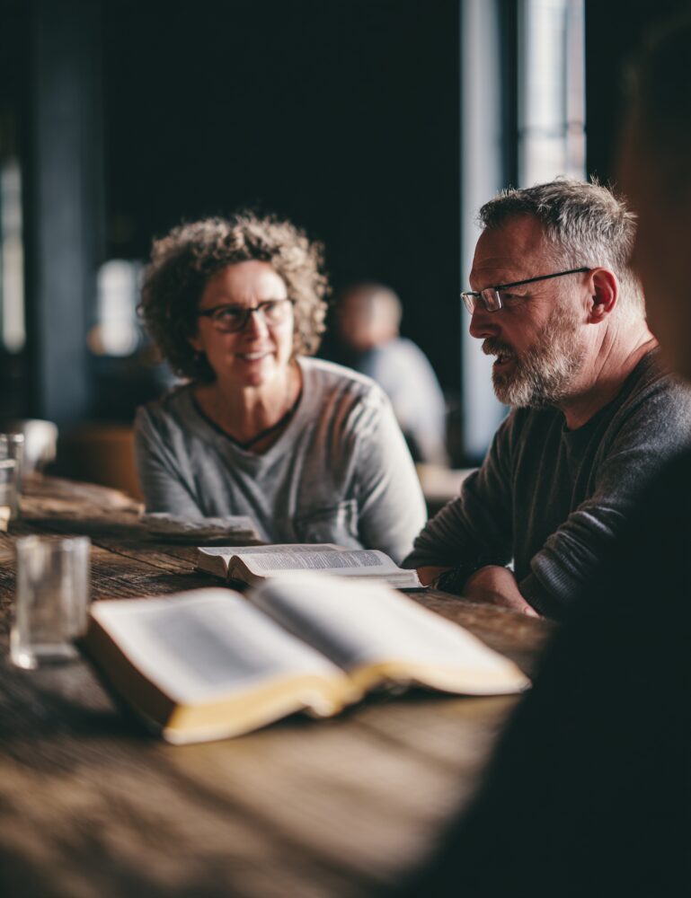 People reading a book together at a table.